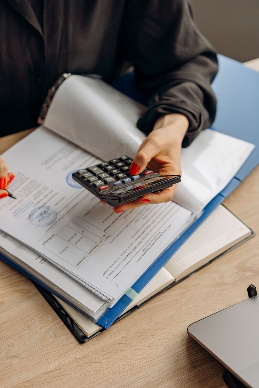 Calculator resting on stamped financial documents